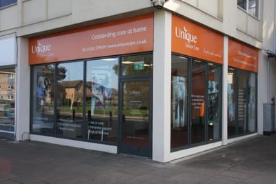 Shop unit The front of Unique Senior Care shop unit. It is a corner unit with an orange banner at the top, with white writing which reads: 'Unique Senior Care. Outstanding care at home.'