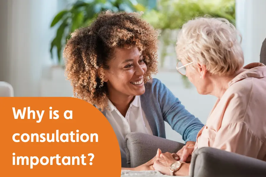 A Caregiver smiling, while holding hands with an older lady, overlayed with the text 'why is a consultation important'