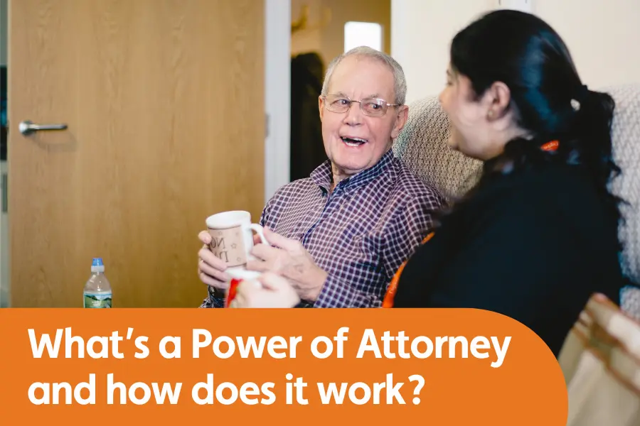 Featured image for blog around Power of Attorney's and how they work in practice. Image shows man smiling at someone while sat on a sofa holding a cup of team