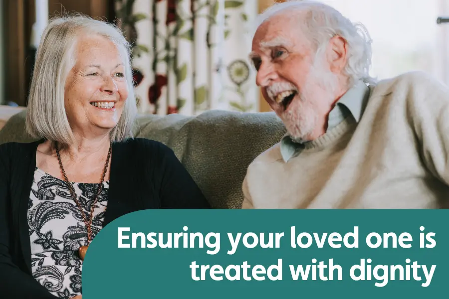 Featured image for blog around ensuring your loved one is treated with dignity and respect in home care. Photo features an elderly man and his Caregiver smiling at each other while sat on a sofa together