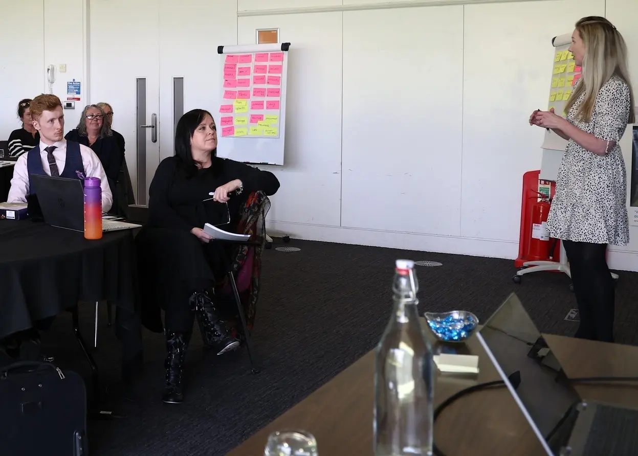 Lucy owen presenting to a group of managers