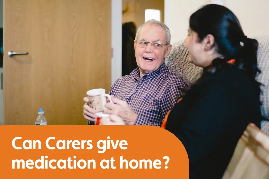 Featured image for blog around medication administration, featuring an older gentleman and a carer sat together on a sofa smiling while talking to eachother