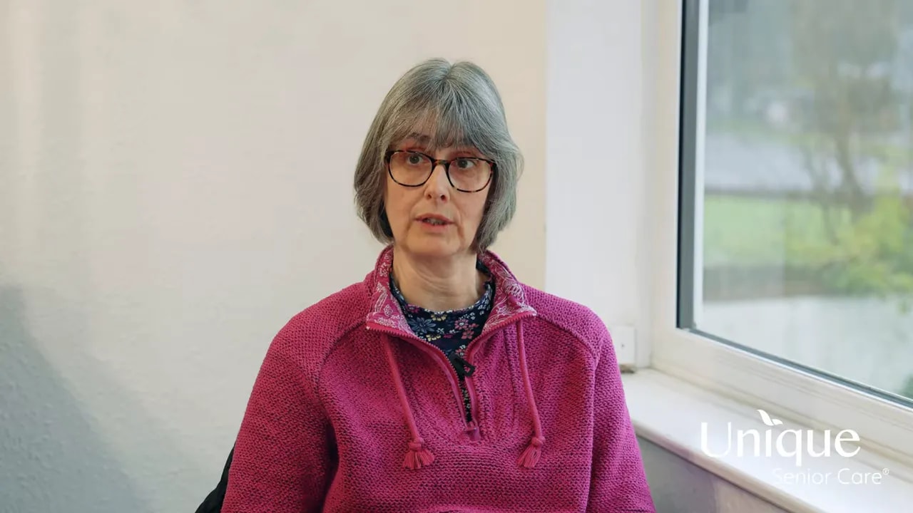 Clear midshot of a woman speaking about home care, neutral expression, window light, high quality