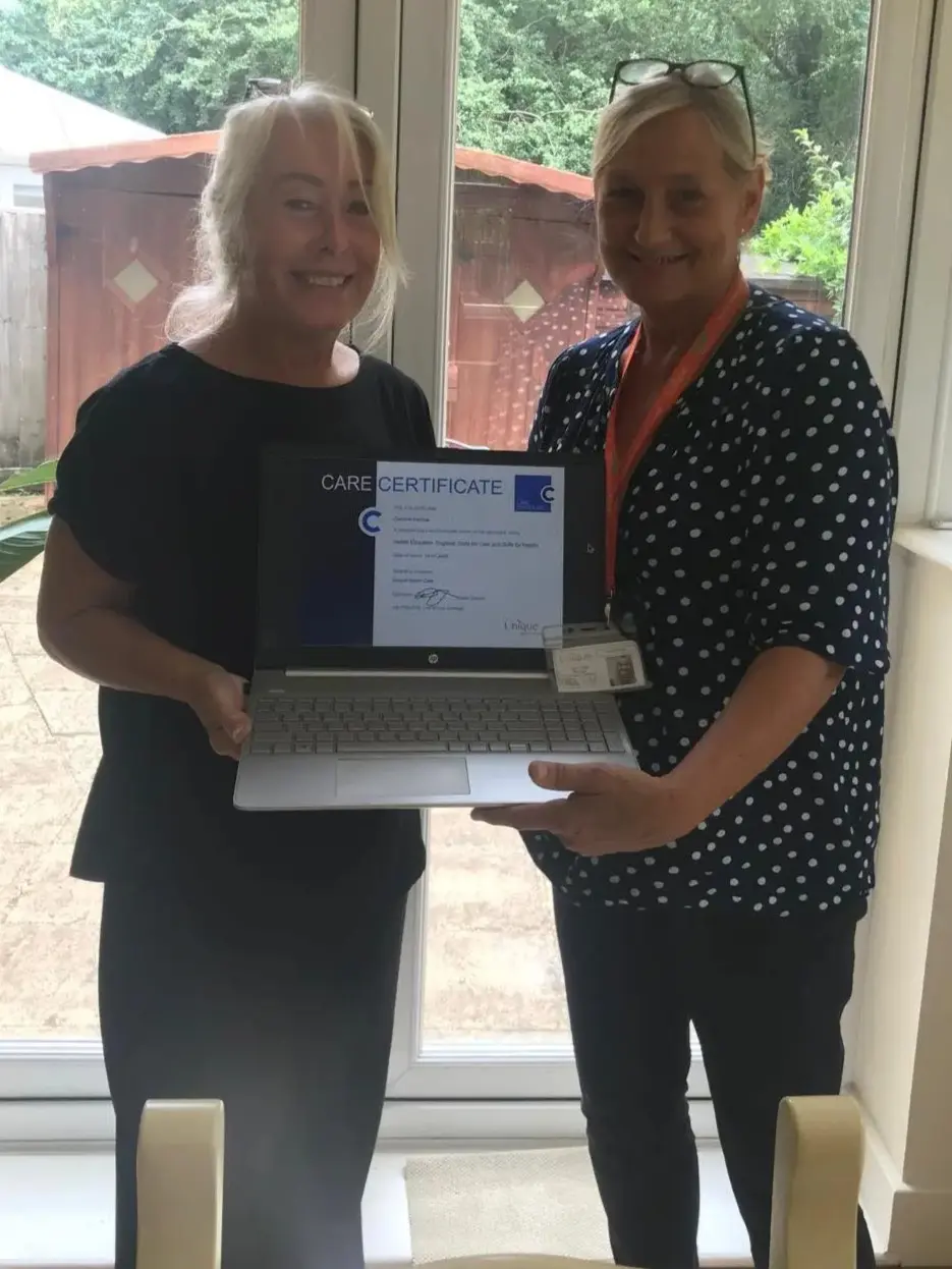 Care Manager, Clare Zinzan, posing with a care certificate alongside a caregiver
