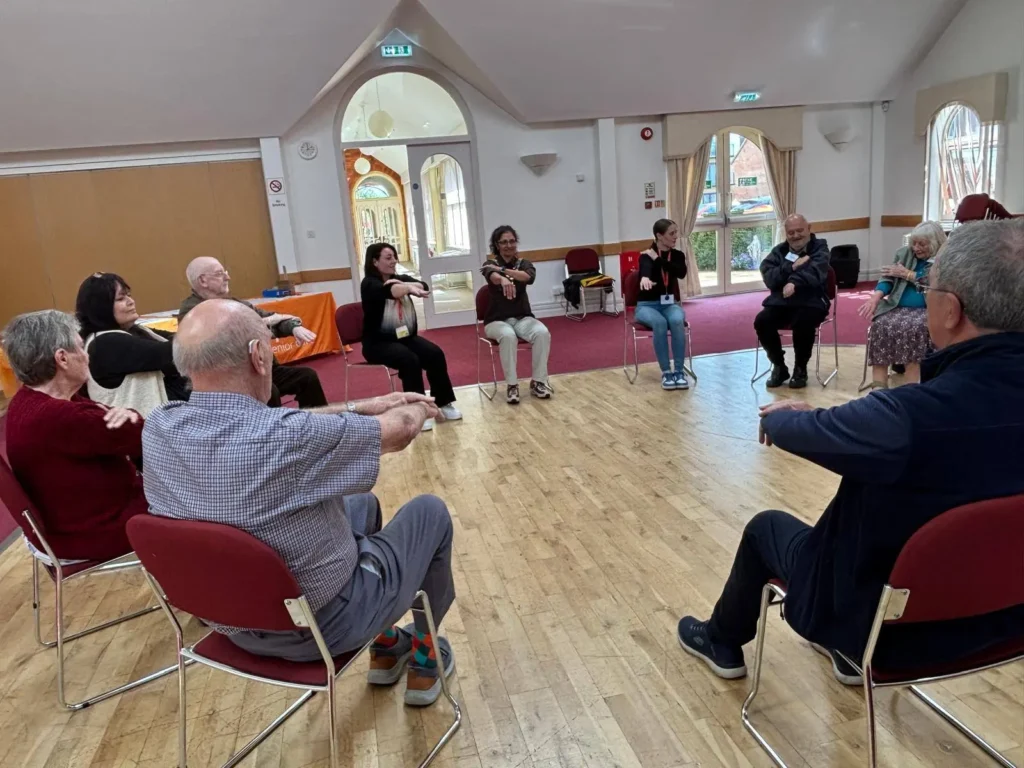A group of attendees at the kenilworth memory cafe enjoying love to move exercises