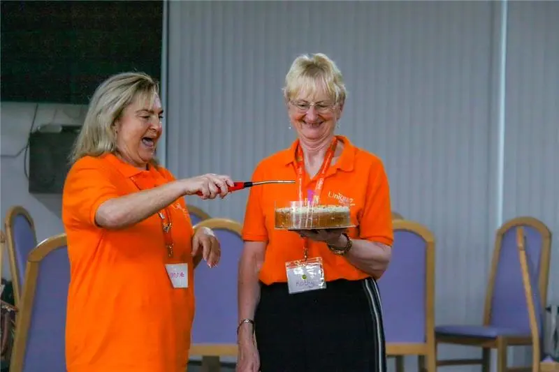 Coordinators at the Solihull memory cafe blowing out candles on a cake to celebrate the cafes first birthday